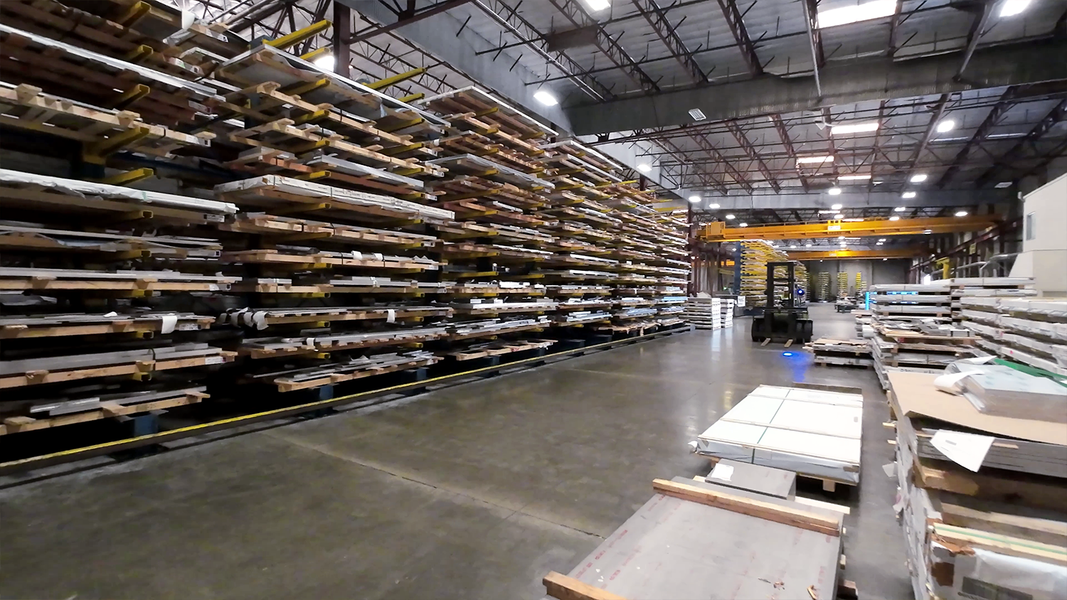 Steel and aluminum sheet and plate inventory is shown on racks in a warehouse