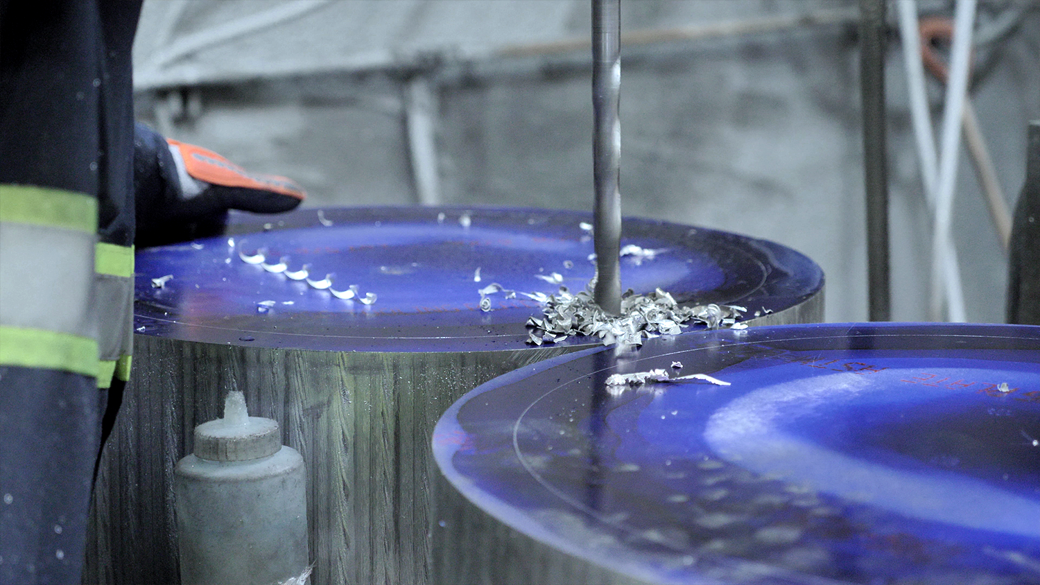 A steel plate is being drilled by a machine